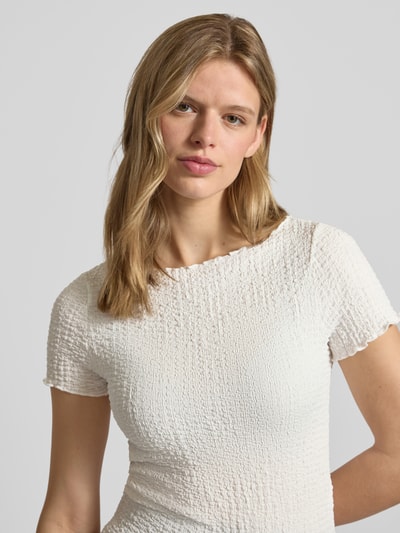Frauenmodel trägt Slim Fit T-Shirt mit Strukturmuster Modell 'Alora' von Noisy May in Offwhite, U-Boot-Ausschnitt, Nahaufnahme Oberkörper.