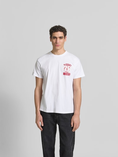 Männermodel trägt Regular Fit T-Shirt aus reiner Baumwolle von Diesel in Weiß mit rotem Label-Applikation und Rundhalsausschnitt, Ganzkörperansicht von vorne. Herren T-Shirt, kurzärmeliges Design, Rückenlänge bei Größe M 70 cm.