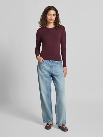 Frauenmodel trägt Regular Fit Langarmshirt aus Baumwoll-Mix Modell 'RILEY' von ONLY in Dunkelrot, glatte Textur, Damen Langarmshirt, Ganzkörperansicht von vorne.