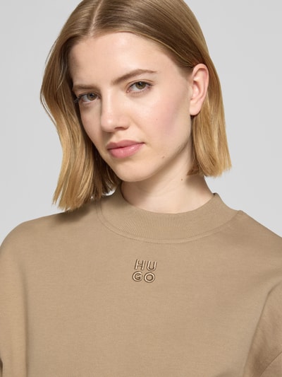 Frauenmodel trägt Regular Fit Sweatshirt aus reiner Baumwolle Modell 'DAXANDRIA' von HUGO, Optik: Unifarben, Logo-Stitching, Rundhals, Langarm, Nahaufnahme Oberkörper.