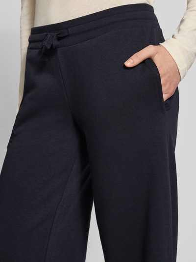 Frauenmodel trägt Wide Fit Sweatpants mit Viskose-Anteil von Review, Baumwoll-Mix, elastischer Bund mit Tunnelzug, Nahaufnahme Oberkörper.