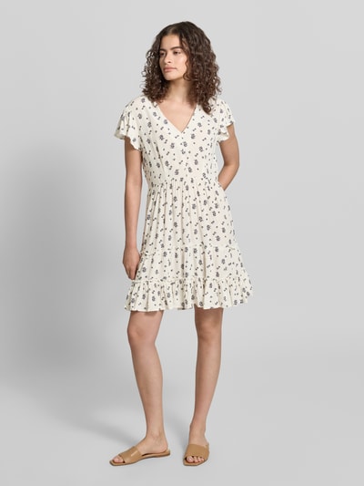 Frauenmodel trägt tailliertes Damen Freizeitkleid von Only, Modell 'CLAUDETTE' mit Allover-Muster, V-Ausschnitt, Volant-Saum, Material: reine Viskose, Ganzkörperansicht von vorne.