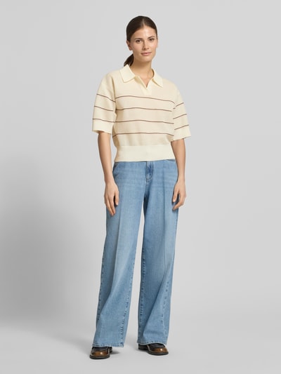 Modelka nosi Strickshirt aus Viskose-Mix mit Polokragen Modell 'Pringi' od OPUS, krój regular fit, kremowe z brązowymi paskami, widok całej sylwetki z przodu.