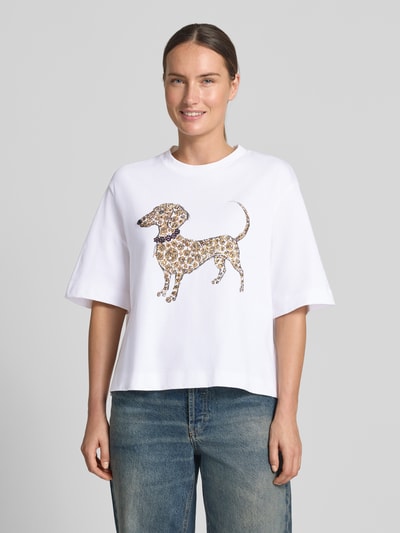 Frauenmodel trägt T-Shirt mit Motiv-Print und Ziersteinbesatz von Rich & Royal, reine Baumwolle, Rundhals, sanfte Passform, Ganzkörperansicht von vorne.