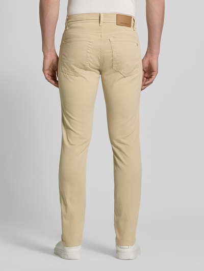 Männermodel trägt Regular Fit Hose mit Eingrifftaschen Modell 'Lyon' von Pierre Cardin aus Baumwoll-Elasthan-Mix, Ganzkörperansicht Rückansicht. Bundweite 41 cm, Innenbeinlänge 80 cm bei Größe 32/32, beige Farbtöne, glatte Struktur.