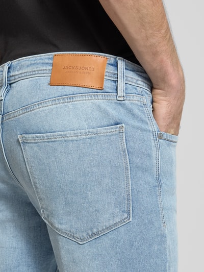 Männermodel trägt Straight Fit Jeans aus Baumwoll-Mix Modell 'GLENN FELIX' von JACK & JONES, hellblauer Denim, 5-Pocket-Design, Nahaufnahme Rückansicht.