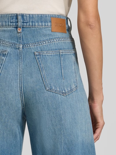 Frauenmodel trägt Straight Fit Jeans aus reiner bawełna Model 'LIABLE' von DRYKORN, 5 kieszeni, jasnoniebieski denim, zapięcie na guzik i zamek błyskawiczny, Szerokość w rozmiarze 27/34: 35 cm, Długość wewnętrzna nogawki 86 cm, detailaufnahme tylnej kieszeni.