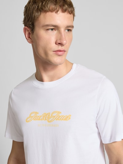 Männermodel trägt Regular Fit T-Shirt mit Logo-Print von JACK & JONES aus reiner Baumwolle, weiß, Rundhalsausschnitt, Nahaufnahme Oberkörper.