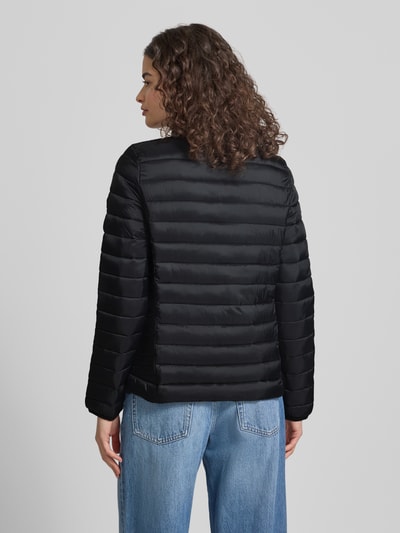 Frauenmodel trägt Steppjacke mit Logo-Stitching Modell 'FUJI' von Superdry in Schwarz, gerader Schnitt, Stehkragen, Rückenansicht, Ganzkörperansicht Rückansicht, Details: Reißverschluss, seitliche Reißverschlusstaschen, Rückenlänge bei Größe S 62 cm, Schulterbreite 40 cm, Brustweite 50 cm, Ärmellänge 69 cm.