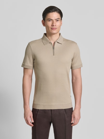 Männermodel trägt Slim Fit Poloshirt mit Reißverschluss Modell 'Franciscojose' von JOOP! Collection, Beige, Strukturmuster, Ganzkörperansicht von vorne.