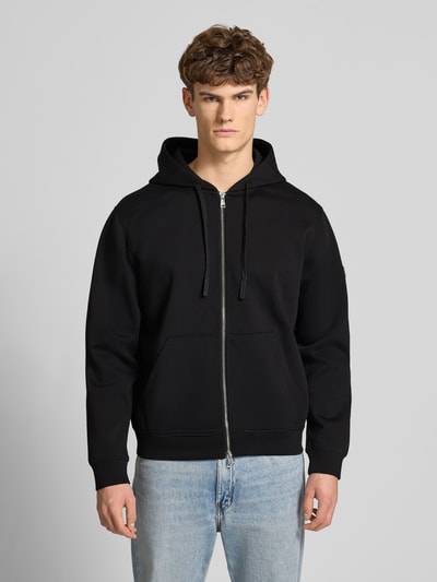 Männermodel trägt Sweatjacke mit Reißverschluss von Guess in zwart, materiaalmix met katoen, los model, capuchon, tunnelkoord, ritssluiting, steekzakken, ribboorden, ruglengte 66 cm, mouwlengte 66 cm, Heren, Ganzkörperansicht von vorne