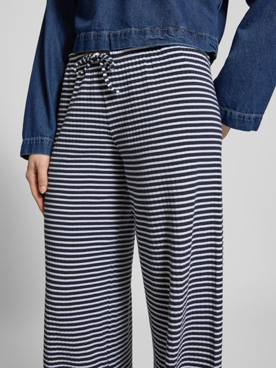 Frauenmodel trägt Wide Fit Stoffhose mit elastischem Bund von Review aus elastischem Baumwoll-Mix, schwarz-weiß gestreift, Nahaufnahme Hüfte.