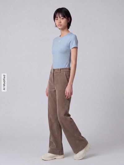Frauenmodel trägt Regular Fit Cordhose mit angedeuteten Taschen Modell 'AMELIE' von CAMBIO in Hellbraun, strukturierte Oberfläche, Ganzkörperansicht von vorne, KI-modifiziertes Bild.