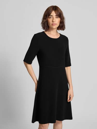Frauenmodel trägt Minikleid aus Viskose-Mix mit Rundhalsausschnitt von Emporio Armani in Schwarz, taillierte Passform, Nahaufnahme Oberkörper.