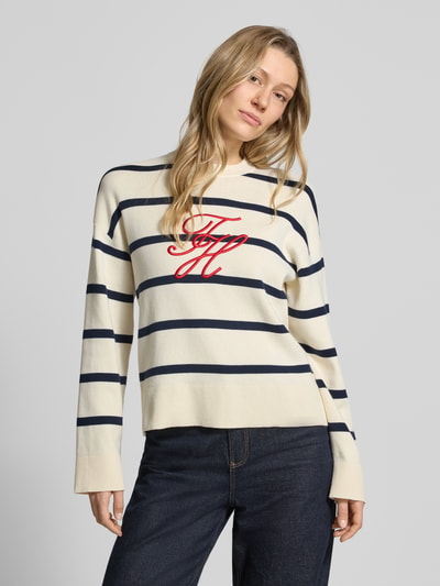 Vrouwenmodel draagt Regular Fit Sweatshirt aus reiner Baumwolle van Tommy Hilfiger met all-over motief, gestreept patroon en gestikt logo, ronde hals, lange mouwen, fijngebreid puur katoen, kleuren crème en donkerblauw, geribde boorden, pasvorm regular fit, Ganzkörperansicht van voren.