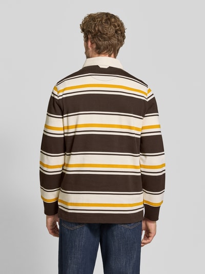 Mannenmodel draagt regular fit poloshirt van puur katoen met bruine, gele en witte strepen van GANT, Ganzkörperansicht Rückansicht.