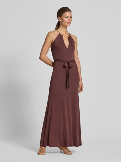 Frauenmodel trägt Abendkleid mit Neckholder in Ring-Optik von Rinascimento in Braun, Maxikleid aus stretchigem Material-Mix mit Bindegürtel, figurbetonter Schnitt, V-Ausschnitt, Ganzkörperansicht von vorne.
