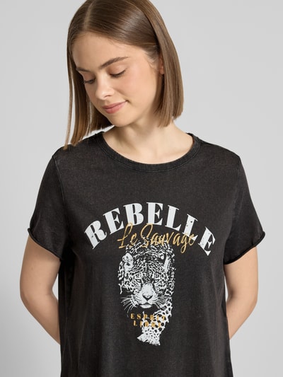 Frauenmodel trägt Leicht ausgestelltes Freizeitkleid aus reiner Baumwolle Modell 'LUCY' von Only, Melange-Optik, Motiv-Print, Glitzer-Print, Mini-Länge, Rundhals, Kurzarm, gerade geschnitten, Jersey, Bio-Baumwolle, Nahaufnahme Oberkörper.