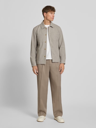 Männermodel trägt Regular Fit Hemdjacke mit Brusttaschen von Les Deux in Beige, mit Kentkragen, Knopfleiste, Label-Patch, Ganzkörperansicht von vorne, Rückenlänge bei Größe M: 69 cm, Schulterbreite bei Größe M: 47 cm, Brustweite bei Größe M: 54 cm, Ärmellänge bei Größe M: 65 cm.