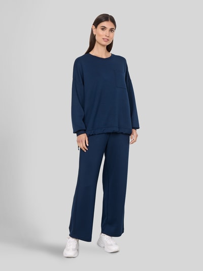 Kobiece modelka nosi spodnie dresowe 'Sweatpants in verkürzter Passform' od Soyaconcept, Mieszanka materiałów z domieszką modalu, prosty krój, jednokolorowy granat, skrócony fason, elastyczny pas z tunelem, boczne wpuszczane kieszenie, widok całej sylwetki z przodu.