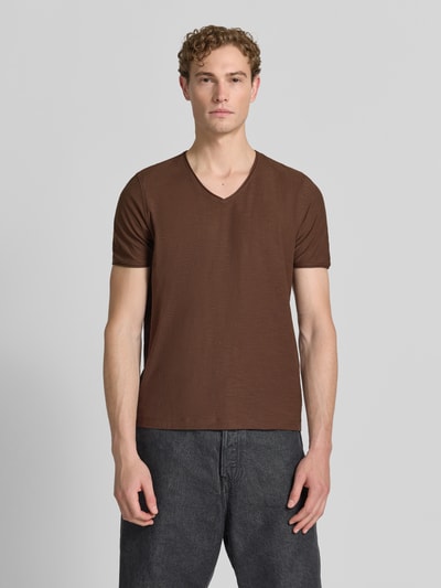 Męski model nosi T-Shirt mit V-Ausschnitt und Rollsaum von MCNEAL z bawełny, krój regular fit, brązowy, długość tyłu w rozmiarze M: 81 cm, całkowity widok z przodu