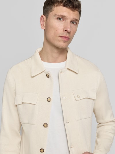 Męski model nosi Regular Fit Hemdjacke mit Brusttaschen od Manuel Ritz z mieszanki bawełny, wykładany kołnierz, kieszenie na piersi, listwa guzikowa, długość tyłu w rozmiarze M: 68 cm, kremowy kolor, faktura gładka, detaliczny widok na górę ciała, na wprost