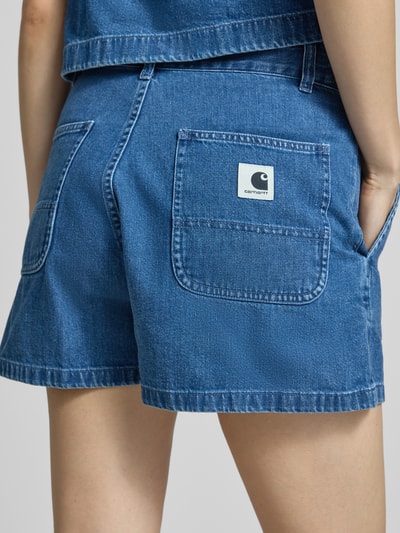 Frauenmodel trägt Shorts in Denim-Optik Modell 'Lova' von Carhartt Work In Progress aus Reine Baumwolle mit Gesäß- und Eingriffstaschen, Nahaufnahme Rückansicht.