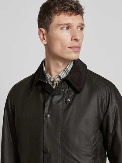 Männermodel trägt Original Wachsjacke mit gewachster Oberfläche, Cordkragen, gefüttert, Außentaschen mit Druckknopf, Nahaufnahme Oberkörper.