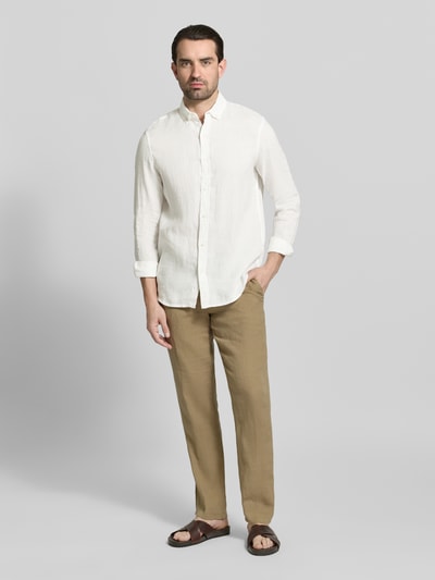 Męski model nosi Regular Fit Leinenhemd mit Button-Down-Kragen von Scotch & Soda, len, krój regular fit, listwa guzikowa, długość tyłu 76 cm, szerokość w rozmiarze M 44 cm, długość rękawów 64 cm, kolor jasny, gładka tekstura, całkowity widok z przodu.