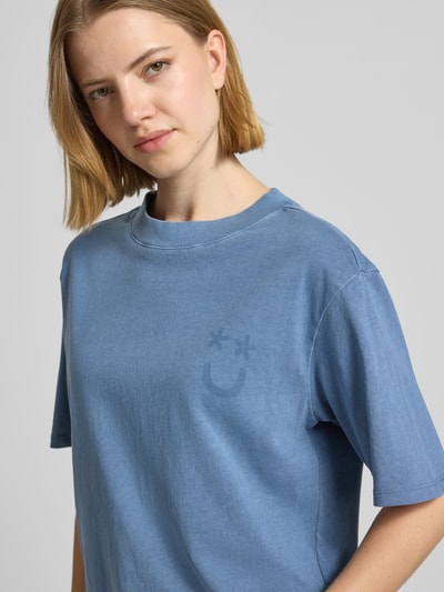 Kobiece modelka nosi damski t-shirt T-Shirt Motiv-Print und Rundhalsausschnitt von Jake*s Casual z bawełny, krój relaxed fit, nadruk z motywem, okrągły dekolt, długość tyłu w rozmiarze S: 52 cm, odcień niebieski, gładka faktura, zbliżenie na górną część ciała