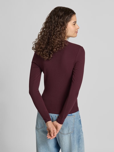 Frauenmodel trägt Regular Fit Langarmshirt aus Baumwoll-Mix Modell 'RILEY' von ONLY in Dunkelrot, glatte Struktur, Ganzkörperansicht Rückansicht. Damen Langarmshirt von ONLY.