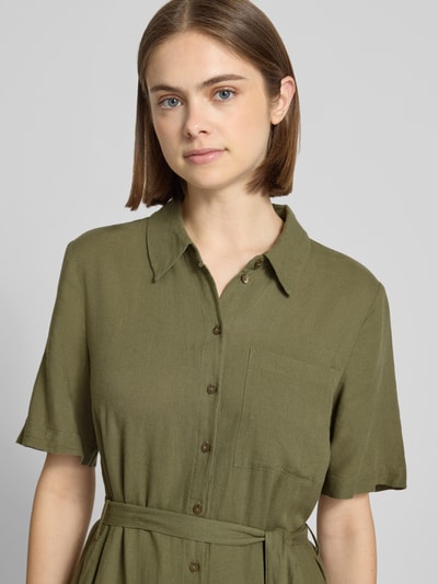 Modelka kobieca nosi Figurą otulającą sukienkę casualową z mieszanki wiskozy i lnu Modell 'PIA' od Pieces, khaki, gładka struktura, krótki rękaw, dekolt w serek, kieszeń na piersi, zapięcie na guziki, flammgarn, midi, ujęcie z przodu na górną część ciała.
