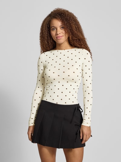 Vrouwenmodel draagt Longsleeve met Label-Stitching model 'Maeve' van OH APRIL, crèmekleurig met zwarte stippen, slim fit, katoenmengsel met viscose, ronde halslijn, bovenlichaam opname van voren.