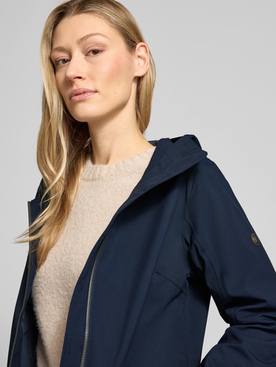Frauenmodel trägt Regular Fit Parka mit Logo-Applikation Modell 'Folka' von Didriksons in Dunkelblau mit Stehkragen, Nahaufnahme Oberkörper.