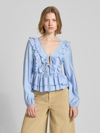 Frauenmodel trägt Regular Fit Langarmbluse aus Viskose-Mix Modell 'ZOEY' von Vero Moda, Optik: Unifarben, Flounce-Detail, Raffung, Binde-Detail, tiefer V-Ausschnitt, verdeckter Reißverschluss, Ärmelform: Langarm, Ärmelabschluss: elastisch, Material: Lyocell-Mix, hellblau mit glatter Textur, Ganzkörperansicht von vorne.