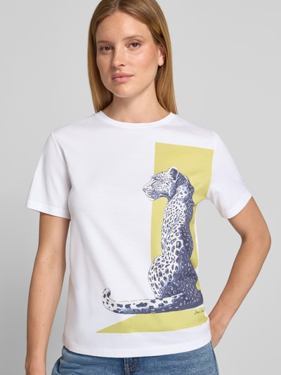 Frauenmodel trägt T-Shirt mit Motiv-Print und Rundhalsausschnitt von Marc Cain in Weiß mit gelbem Akzent, reine Baumwolle, Regular Fit, Nahaufnahme Oberkörper.