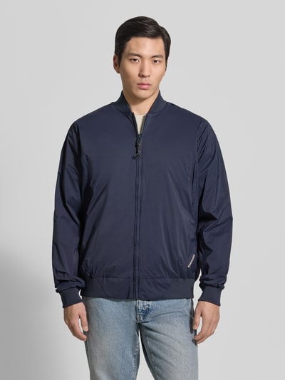 Männermodel trägt dunkelblauen Blouson mit Stehkragen, Reißverschluss, Label-Detail und Gerippte-Abschlüsse von GOFRANCK, Gerader-Schnitt, Nahaufnahme Oberkörper. Kontext: Rückenlänge bei Größe M 70 cm, Schulterbreite 45 cm, Brustweite 63 cm, Ärmellänge 71 cm. Modell 'MILD'.