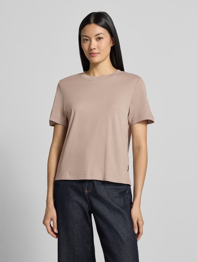 Vrouwenmodel draagt Regular Fit t-shirt van puur katoen van s.Oliver RED LABEL in lichtbruin, donkerblauwe broek, egale textuur, vooraanzicht bovenlichaam.