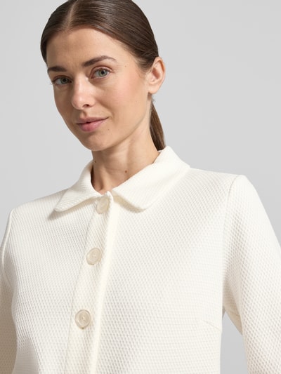 Frauenmodel trägt Regular Fit Blazer mit Strukturmuster und Pattentaschen von Betty Barclay in Weiß, Knopfleiste, Nahaufnahme Oberkörper. Rückenlänge 55 cm, Brustweite 49 cm, Ärmellänge 65 cm, Größe 36.