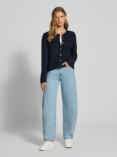 Frauenmodel trägt Loose Fit Strickjacke mit Rundhalsausschnitt Modell 'SIMONI' von ONLY, dunkelblau, helle Jeans, glatte Textur, Ganzkörperansicht von vorne, Damen Strickjacke von ONLY.