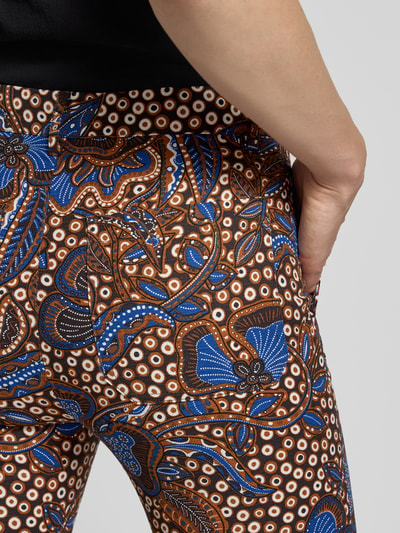 Frauenmodel trägt Schmale Hose aus Baumwoll-Mix Modell 'DONDE' von Weekend Max Mara mit Allover-Muster in Braun, Blau und Weiß, Detailaufnahme.