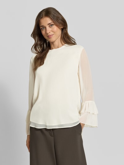 Frauenmodel trägt Bluse mit Volant-Ärmeln von COMMA in Creme, lockere Passform, Rundhalsausschnitt, Ganzkörperansicht von vorne.