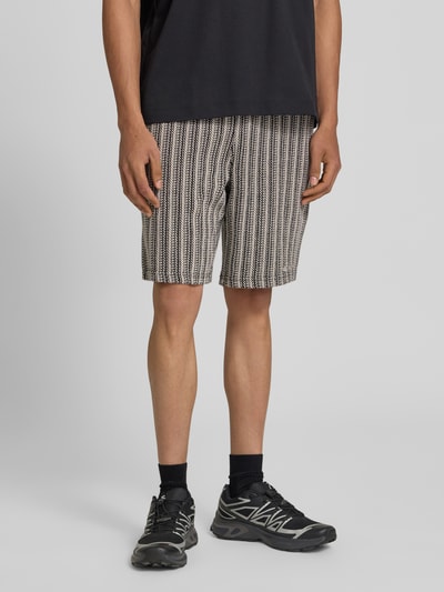 Männermodel trägt Straight Fit Shorts mit Strukturmuster Modell 'Forno' von Pegador aus reiner Baumwolle, Nahaufnahme Oberschenkel. Bundweite Größe M: 42 cm, Innenbeinlänge: 23 cm.