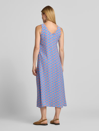 Frauenmodel trägt Midikleid aus Viskose mit V-Ausschnitt von Smith and Soul im Allover-Look, A-Linie, blaue und rote Muster, Ganzkörperansicht Rückansicht.