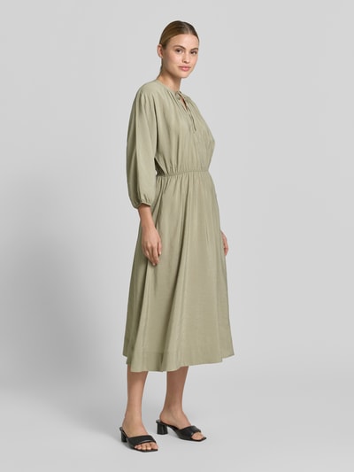 Frauenmodel trägt Midikleid mit Eingrifftaschen Modell 'Worty' von OPUS aus Modal-Mix in A-Linie, Schlüsselloch-Ausschnitt, Ganzkörperansicht von vorne. Rückenlänge bei Größe 36: 121 cm, Brustweite: 32 cm, Ärmellänge: 35 cm.