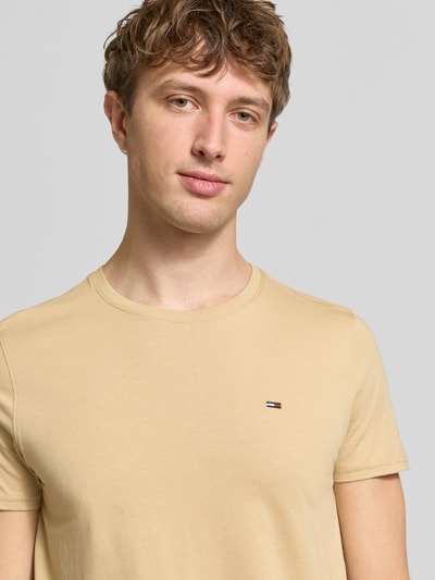 Männermodel trägt Regular Fit T-Shirt aus reiner Baumwolle von Tommy Jeans, Optik: Unifarben, Logo-Stitching, Nahaufnahme Oberkörper.
