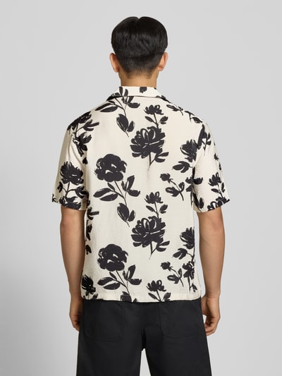 Männermodel trägt Regular Fit Freizeithemd aus Viskose-Mix von REVIEW, creme mit schwarzen Blumen, Reverskragen, 1/2-Arm, Knopfleiste, Rückenlänge 74 cm, Schulterbreite 54 cm, Ärmellänge 30 cm, Ganzkörperansicht Rückansicht.
