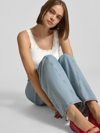Vrouwenmodel draagt witte slim fit body van katoenmix model 'VINI' van ONLY, Dames body, lichtblauwe broek, vooraanzicht, zittend