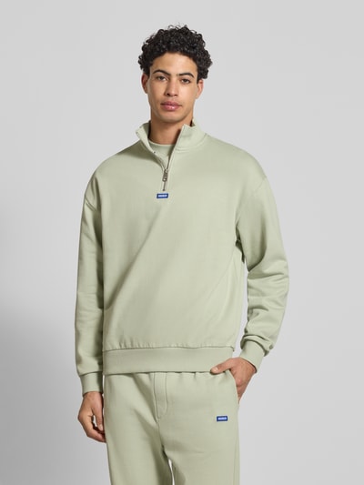 Męski model nosi Regular Fit Troyer aus reiner Baumwolle Modell 'NEELER' od Hugo Blue, kolor jednolity, z zamkiem, detal z logo, krój regular fit, długi rękaw, ściągacze, materiał bawełna, tekstura sweat. Ganzkörperansicht von vorne.