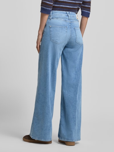Frauenmodel trägt jasnoniebieskie jeansy wide fit z mieszanki bawełny i lyocellu z odpinaną materiałową tasiemką, 5 kieszeni, model 'Sventy' od Raffaello Rossi, wzór z logo, zapięcie na guzik i zamek błyskawiczny, szerokość w rozmiarze 36: 38 cm, długość wewnętrzna nogawki w rozmiarze 36: 80 cm, widok całej sylwetki z tyłu.